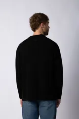 Sweater negro de tejido grueso con cuello redondo y corte relajado.