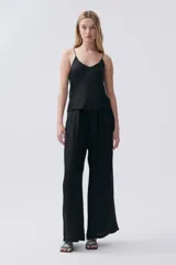 Pantalón palazzo negro de viscosa con tiro alto, bolsillos laterales y pinzas en el frente.