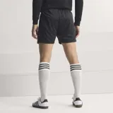 Short de fútbol Adidas inspirado en el diseño de 1994 de la selección de Alemania. Es de color negro con un panel lateral estampado con rombos en los colores de la bandera alemana (negro, rojo y amarillo). Presenta el escudo de la DFB en la pierna derecha, cordón de ajuste tricolor y corte holgado.