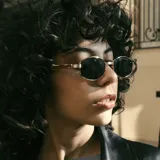 Lentes de sol con armazón metálico dorado y forma hexagonal. Cuentan con cristales oscuros con protección UV400.
