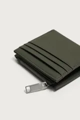 Cartera monedero de acabado engomado en color verde militar, con compartimento principal para billetes, ranuras exteriores para tarjetas y monedero lateral con cierre de cremallera.