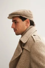 Boina con visera de lana fina uruguaya natural, sin teñir, con diseño de tejido texturizado en tonos beige y marrón.