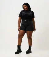 Short mom de jean color negro con lavado marmolado, cintura alta y calce holgado, con bolsillos funcionales y cierre frontal con botón y cremallera.