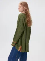 Sweater de cuello redondo con diseño de tejido en relieve de rombos, manga larga y calce holgado. Presenta logo bordado en el pecho y aberturas laterales en el ruedo.