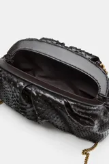 Bolso de mano tipo pouch con estampado animal y cierre magnético.