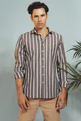 Camisa de manga larga en color salmón con estampado de pequeños motivos geométricos oscuros, cuello clásico y cierre frontal con botones.