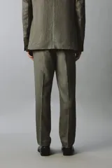 Pantalón de traje regular fit de lino color verde militar, con bolsillos laterales y bolsillos traseros de doble vivo con botón. Cierre frontal con cremallera y botón.