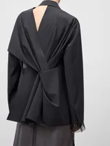 Blazer de corte recto y holgado en color gris melange, con solapas clásicas y cierre frontal de un solo botón. Presenta mangas largas y un diseño estructurado con detalles de costuras visibles.
