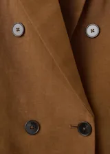 Blazer cruzado de lino y viscosa color marrón tostado, de corte recto y largo, con cuello pico con solapa de muesca, bolsillos laterales con solapa y cierre de doble botonadura.