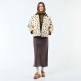 Chaqueta de sherpa color crema con estampado floral en tonos marrones, amarillos y verdes. Tiene cuello camisero y ribete de pana marrón.