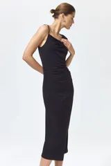 Vestido midi negro confeccionado en punto de crepé, de corte ajustado con escote asimétrico, un bretel fino y un hombro drapeado. Presenta frunces laterales que generan un efecto drapeado en la cintura y largo hasta la rodilla.