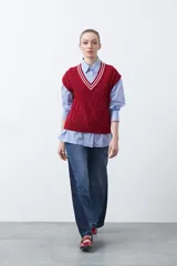 Chaleco de punto color bordó, con diseño de rombos y trenzas en relieve. Escote en V con ribete blanco y rojo.