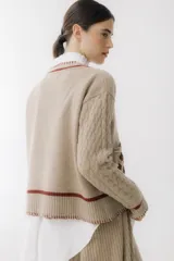 Sweater color borgoña con escote en V, mangas largas con diseño de ochos, bolsillos frontales y bordados con forma de hojas.