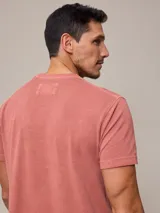 Remera beige de piqué con cuello redondo y logo bordado en blanco.