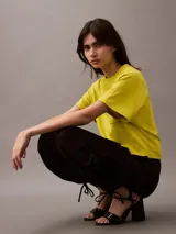 Remera corta color amarillo con cuello redondo, mangas cortas y bolsillo en el pecho con escudo bordado en blanco.