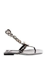 Sandalias plateadas con estampado animal print, tira de dedo y cadena decorativa con dije de cristal.