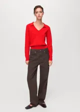 Jersey de punto fino color rojo, con cuello en V y solapas tipo polo, de manga larga y diseño recto.