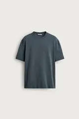 Camiseta de corte relajado, color gris oscuro, con cuello redondo y manga corta.