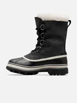 Bota de nieve Sorel modelo Caribou, con diseño impermeable de caña media. Presenta una parte superior de nubuck negro con costuras selladas, cordones frontales y una base de goma vulcanizada resistente. Incluye un forro interior de fieltro y detalle de pelo sintético en el borde superior.