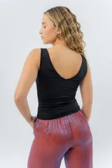 Top ajustado color gris claro, con escote en V pronunciado tanto en el frente como en la espalda, y tirantes anchos.