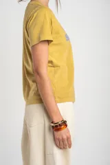 Remera de algodón peinado color pistacho, con cuello redondo, mangas cortas y estampado frontal con la leyenda "La Spiaggia By The Sea Summer Club" en tono celeste.
