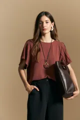 Pantalón de vestir negro de corte ancho y silueta recta, con diseño de tiro medio y bolsillos laterales. Presenta una caída fluida y estructurada, ideal para un look formal o de oficina.