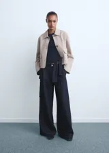 Pantalón de jean estilo wideleg de tiro medio, con pinzas delanteras, cierre de botón y cremallera, y cuatro bolsillos.