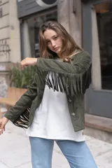 Chaqueta color beige de gamuza sintética con flecos en mangas y canesú, cuello camisero y cierre con botones.