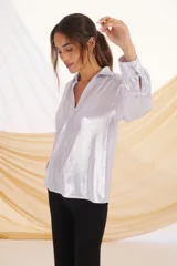 Camisa plateada de manga larga con cuello clásico y puños abullonados con detalle de botones.