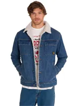 Chaqueta de denim azul con interior y cuello de corderito sherpa sintético. Cuenta con bolsillos frontales con solapa en el pecho, bolsillos laterales tipo welt, cierre frontal de botones metálicos y una pequeña etiqueta con el logo de la marca.
