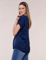 Blusa azul marino de silueta relajada confeccionada en satén, con escote redondo, hombros caídos y mangas cortas de corte japonés con puño doblado.