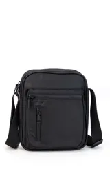 Morral de tela impermeable color negro, de forma rectangular y diseño compacto. Cuenta con correa ajustable para llevar al hombro o cruzado, y múltiples compartimentos con cierre, incluyendo un bolsillo frontal vertical con cierre.