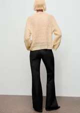 Jersey de punto calado color beige, con cuello redondo y diseño recto de manga larga.