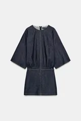 Vestido corto de denim azul oscuro, con cuello redondo, mangas amplias de largo tres cuartos y cintura elástica con cinturón integrado del mismo tejido. Presenta costuras a contraste y cierre posterior con cremallera oculta.