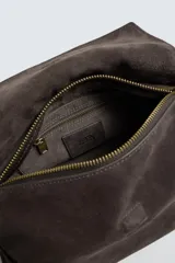 Bolso tipo bandolera fabricado en piel con acabado serraje. Cuenta con compartimento principal con cierre de solapa magnética y cremallera, asa de mano superior y asa de hombro ajustable.
