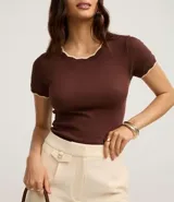 Top de manga corta ajustado al cuerpo, color marrón oscuro, con cuello redondo y bordes festoneados en color crema o beige claro.