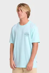 Remera Billabong de manga corta color celeste, con estampado gráfico en la espalda con diseño de una quilla de tabla de surf, un sol y la leyenda "Feeling Free Since Nineteen Seventy Three".