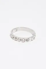 Pulsera rígida de metal plateado con cristales facetados en forma de corazón incrustados a lo largo de su superficie, equipada con un cierre de bisagra.