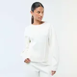 Buzo blanco de cuello redondo, con mangas largas abullonadas y diseño holgado.