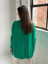 Sweater de punto color verde, con cuello redondo, mangas largas con puños acanalados y diseño holgado con detalle de costura vertical central.
