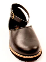 Zapato plano tipo bailarina o mary jane, color gris claro, con puntera redonda y tira de ajuste con hebilla en el tobillo. Suela negra.