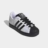 Championes Adidas Superstar II, blancos con detalles en negro, incluyendo las tres tiras laterales y la puntera de goma. Cordones negros y suela negra.