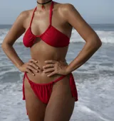 Conjunto de bikini rojo, compuesto por corpiño con escote en U y tiras para atar al cuello, y bombacha brasilera con tiras laterales para ajustar.