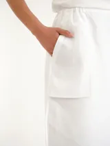 Pollera larga blanca de lino, con tajos laterales y diseño de tiro alto.