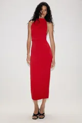 Vestido largo de corte fluido con cuello halter y espalda descubierta. Presenta un detalle de drapeado lateral y bajo recto.