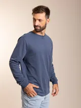 Remera blanca de manga larga con cuello redondo y logo bordado de un pájaro en el pecho.