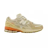 Championes urbanos New Balance modelo 1906, con diseño técnico de running. Presentan una combinación de tonos beige y crema en el cuerpo de malla y superposiciones sintéticas, con detalles en color naranja en la entresuela y logotipos. Cuentan con suela de goma y tecnología de amortiguación.