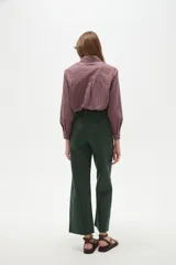 Pantalon tipo jean de corte flare y tiro alto, color verde oscuro, con cierre frontal y bolsillos.