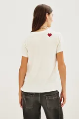 Remera de algodón color blanco con estampa frontal tipográfica en tonos rojo y negro.