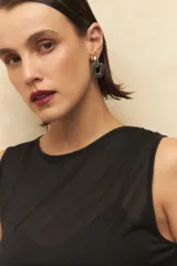 Top sin mangas de color negro, confeccionado en tejido elastizado con diseño de frunces laterales y cuello redondo.